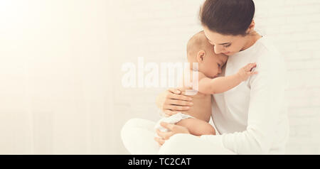 Junge Mutter ihr neugeborenes Kind in den Händen halten