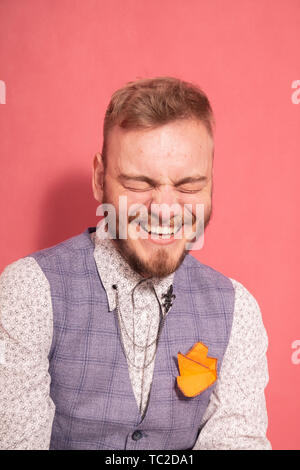 Einen jungen offen Laughing Man head-shot, die Augen geschlossen. rosa Hintergrund. Formelle Kleidung tragen. Stockfoto
