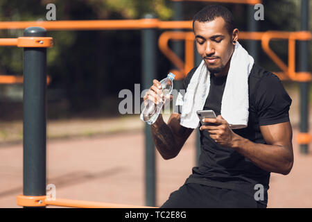 Fitness Mann mit Telefon, nachdem Training im Freien Stockfoto