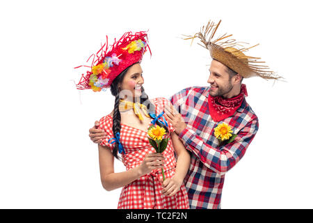 Lächelnd Mann und junge Frau in festlicher Kleidung mit Sonnenblumen isoliert auf weißem Stockfoto