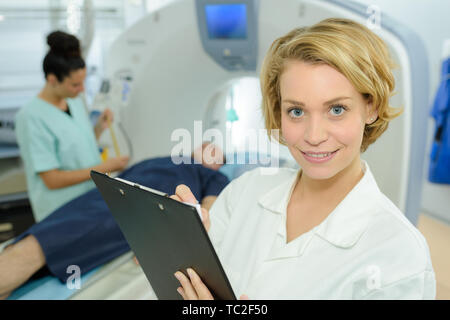 Portrait von Frau Doktor holding Zwischenablage Scanner im Hintergrund Stockfoto