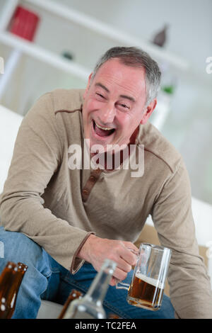 Zufrieden Mann mit Bier zu Hause Stockfoto