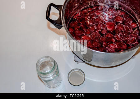 Putting gekocht strawberyes in die Gläser - Zucker adiction Stockfoto