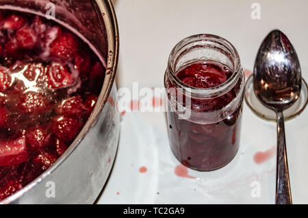 Putting gekocht strawberyes in die Gläser - Zucker adiction Stockfoto