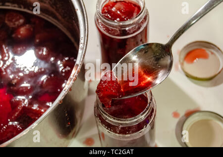 Putting gekocht strawberyes in die Gläser - Zucker adiction Stockfoto