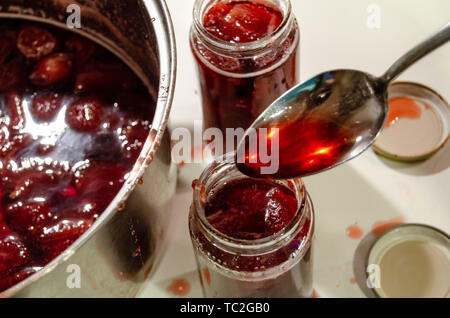 Putting gekocht strawberyes in die Gläser - Zucker adiction Stockfoto