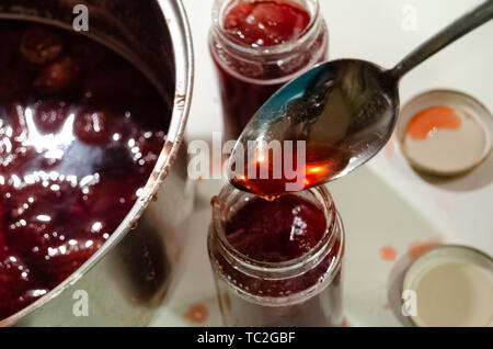 Putting gekocht strawberyes in die Gläser - Zucker adiction Stockfoto