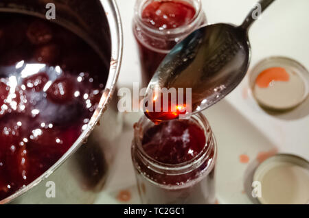 Putting gekocht strawberyes in die Gläser - Zucker adiction Stockfoto