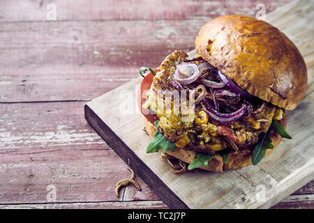 Köstliche trendy mealworm Burger auf ein knuspriges Brötchen mit Rucola, Tomate und Zwiebel Garnituren gesehen schließen oben mit Platz für Werbung im Menü kopieren Stockfoto