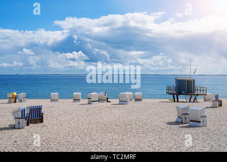 Liegen und lifeguard Tower auf breiten Sandstrand vor blauem Meer und Himmel an einem sonnigen Tag Stockfoto