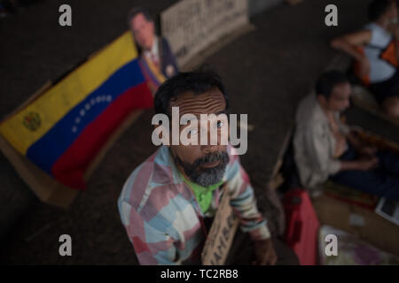 04. Juni 2019, Venezuela, Caracas: ein Mann sitzt vor einem venezolanische Fahne in einem Camp, wo ehemalige Ölarbeiter Aufmerksamkeit sind mit einem Hungerstreik. Einige Männer haben im Hungerstreik für sechs Tage. Ehemalige Exxon Mobil Oil Company Arbeiter fordern Zahlung von Vereinbarungen und Sozialversicherungsbeiträge hervorragende Nach der Verstaatlichung von US Oil Company Projekt in Venezuela. "Präsident Maduro und seine Minister wird sicherlich drei Mahlzeiten am Tag in Ruhe essen. Er auch an uns denken [.], unserer legitimen Forderung sollte", sagt der 60-jährige Humberto Cifontes. Foto: Rafael Ihr Stockfoto