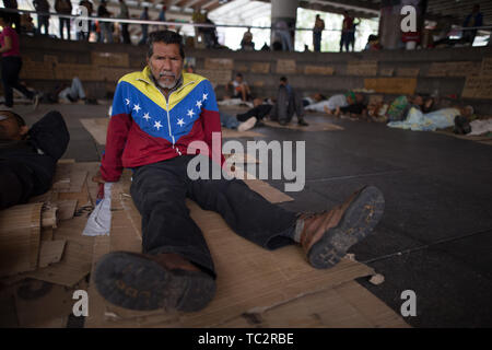 04. Juni 2019, Venezuela, Caracas: ein Mann in einer Jacke mit den Farben der Flagge Venezuelas ist in einem Camp, wo ehemalige Ölarbeiter Aufmerksamkeit sind mit einem Hungerstreik sitzen. Einige Männer haben im Hungerstreik für sechs Tage. Ehemalige Exxon Mobil Oil Company Arbeiter fordern Zahlung von Vereinbarungen und Sozialversicherungsbeiträge hervorragende Nach der Verstaatlichung von US Oil Company Projekt in Venezuela. "Präsident Maduro und seine Minister wird sicherlich drei Mahlzeiten am Tag in Ruhe essen. Er auch an uns denken [.], unserer legitimen Forderung sollte", sagt der 60-jährige Humberto Stockfoto