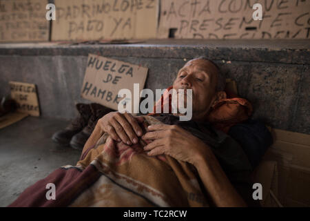 04. Juni 2019, Venezuela, Caracas: ein Mann liegt in einem Camp, wo ehemalige Ölarbeiter Aufmerksamkeit sind mit einem Hungerstreik. Einige Männer haben im Hungerstreik für sechs Tage. Ehemalige Exxon Mobil Oil Company Arbeiter fordern die Zahlung von Abfindungen und Sozialabgaben nach der Verstaatlichung der US Oil Company Projekt in Venezuela. "Präsident Maduro und seine Minister wird sicherlich drei Mahlzeiten am Tag in Ruhe essen. Er auch an uns denken [.], unserer legitimen Forderung sollte", sagt der 60-jährige Humberto Cifontes. Foto: Rafael Hernandez/dpa Stockfoto