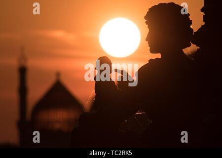 Dresden, Deutschland. 04 Juni, 2019. Die Sonne hinter ein Denkmal auf der Brühlschen Terrasse. Das Denkmal wurde von Johannes Schilling geschaffen und der Bildhauer Ernst Rietschel gewidmet. Im Hintergrund steht das ehemalige Dresdner Zigarettenfabrik Yenidze. Credit: Sebastian Kahnert/dpa-Zentralbild/dpa/Alamy leben Nachrichten Stockfoto