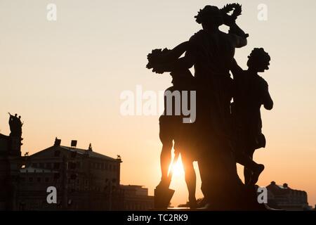 Dresden, Deutschland. 04 Juni, 2019. Die Sonne hinter einer Gruppe von Statuen von Johannes Schilling auf der Brühlschen Terrasse. Die Semperoper können im Hintergrund gesehen werden. Credit: Sebastian Kahnert/dpa-Zentralbild/dpa/Alamy leben Nachrichten Stockfoto