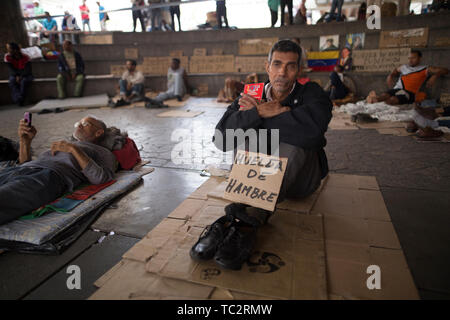 04. Juni 2019, Venezuela, Caracas: "Hungerstreik", auf Karton von Humberto Cifontes, einem ehemaligen Mitarbeiter, der die Aufmerksamkeit auf sich zieht mit ex-Kollegen in einen Hungerstreik geschrieben. Einige in der Gruppe bereits im Hungerstreik für sechs Tage. Ehemalige Exxon Mobil Oil Company Arbeiter fordern Zahlung von Vereinbarungen und Sozialversicherungsbeiträge hervorragende Nach der Verstaatlichung von US Oil Company Projekt in Venezuela. "Präsident Maduro und seine Minister wird sicherlich drei Mahlzeiten am Tag in Ruhe essen. Er auch an uns denken [.], unserer legitimen Forderung sollten", sagt t Stockfoto