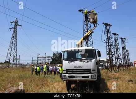 (190605) - homs, Juni 5, 2019 (Xinhua) - Weibliche elektrische Arbeiter der Fix eine hohe Spannung Strom Linie in Homs Provinz Syrien am 30. Mai 2019. Als der Krieg in Syrien polterte, syrische Frauen begannen in mehr Arbeitsplätze als reguläre Arbeit und Kindererziehung, als viele Männer hatte die Armee oder das Land Zuflucht zu suchen. Die Jobs, die Frauen im Land zunehmend Tun gehören die Reparatur von Autos, fahren Busse oder Taxis, und interessanterweise mit einem Kran die Hochspannungsleitungen zu erreichen und sie zu beheben, trotz aller Herausforderungen wie der Familie opp Stockfoto