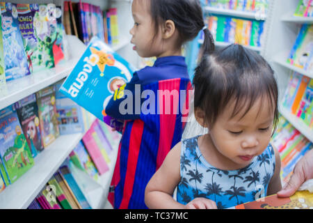 CHIANGMAI, THAILAND - Mai 3,2019: Kleines Kind erforscht die Bücherregale mit Mama in Book Store. Hochauflösende Bilder Galerie Stockfoto