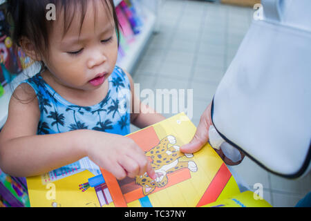 CHIANGMAI, THAILAND - Mai 3,2019: Kleines Kind erforscht die Bücherregale mit Mama in Book Store. Hochauflösende Bilder Galerie. Stockfoto