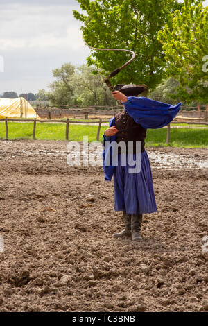 Kalocsa, Puszta, Ungarn - 23. Mai 2019: Traditionelle Ungarische Csikos cowboy anzeigen Fähigkeiten mit Peitsche in Corral. Stockfoto