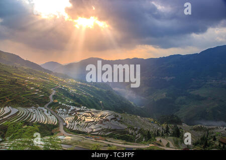 Den Sonnenaufgang der Terrassen in der südöstlichen Provinz Guizhou, die Sonne durch die Wolken und glänzt auf den Terrassen. Stockfoto