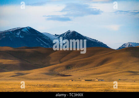 Auf der Bayinbrook Prairie im frühen Frühling, unter den riesigen schneebedeckten Berge sind die Häuser der Hirten. Stockfoto