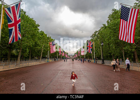 Ein süßes kleines Mädchen tanzt auf der Mall mit Union und amerikanische Flaggen und der Buckingham Palace in der Ferne für Donald Trump Besuch im Juni 2019 Stockfoto