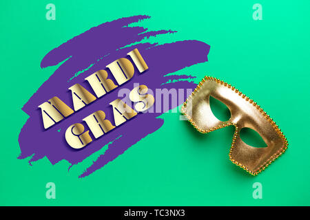 Festliche Maske mit Text MARDI GRAS (auch als Fat Tuesday bekannt) auf farbigen Hintergrund Stockfoto