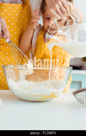 Selektiver Fokus der Mutter helfen, aufgeregt Tochter im Vorfeld vorbereiten Teig in Küche Stockfoto