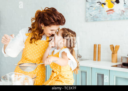 Selektiver Fokus der süße Mutter und Tochter sieben Mehl zusammen in der Küche Stockfoto
