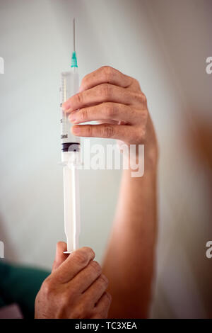 7/8-Ansicht einer Krankenschwester mit einer Spritze in der Hand. Stockfoto
