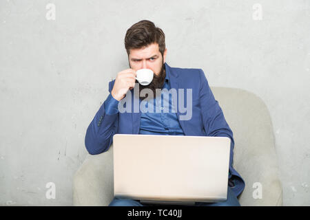 Moderne Geschäftsmann. Projekt Manager. Geschäftsmann Laptop. Mann trinken Kaffee im Büro. Reaktion auf geschäftliche E-Mails. Digitales Marketing. Im Internet surfen. Online kaufen. Geschäftliche Korrespondenz. Stockfoto