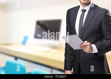 Geschäftsmann mit Tablet mit verschwommenen Büro Stockfoto