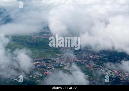 Luftaufnahme der Berge, Felder, Dörfer, Städte unter dem blauen Himmel und weißen Wolken des Heilongjiang Fluss Stockfoto