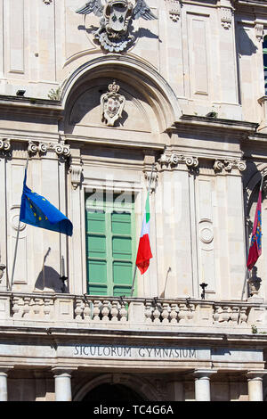 Vertikale Fotografie erfassen Vorderseite Außenfassade der historischen Universität in Catania, Sizilien, Italien. Barocke Architektur Stil, grünes Fenster und winkte italienische Fahne und Flagge der EU. Stockfoto