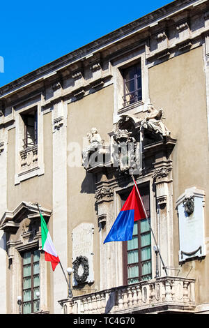 Vertikale Foto erfassen Vorderseite Fassade des historischen Rathauses in Catania, Sizilien, Italien. Auf dem Balkon gibt es wehenden Fahnen von Italien und Stadt Catania. Stockfoto