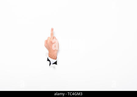 Mann zeigt mittleren Finger aus dem Loch in der Wand auf Weiß mit Kopie Raum Stockfoto