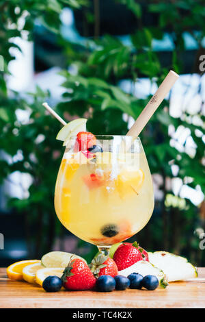 Nahaufnahme einer bunten fancy Trendige Cocktail garniert mit frischen Früchten, zurück Natürliches Licht trinken Bokeh, unscharf, kreative Zusammensetzung, Aperitif Stockfoto