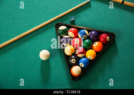 Billard Kugeln im Dreieck Rack mit Cues auf Tisch Stockfoto