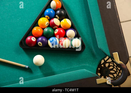 Billard Kugeln im Dreieck Rack mit Cue auf Tisch Stockfoto