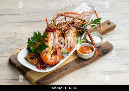 Nahaufnahme der gegrillt sautierte Big river Garnelen Fischplatte gemischter Salat pikanter Sauce Mayonnaise in einem Holz Brett fancy Platte isolierte natürliche Licht zurück Stockfoto