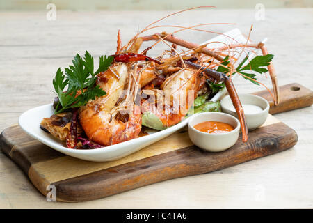 Nahaufnahme der gegrillt sautierte Big river Garnelen Fischplatte gemischter Salat pikanter Sauce Mayonnaise in einem Holz Brett fancy Platte isolierte natürliche Licht zurück Stockfoto