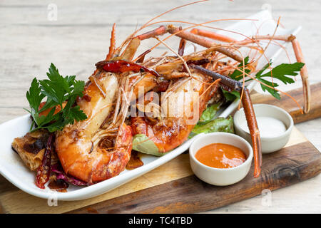 Nahaufnahme der gegrillt sautierte Big river Garnelen Fischplatte gemischter Salat pikanter Sauce Mayonnaise in einem Holz Brett fancy Platte isolierte natürliche Licht zurück Stockfoto