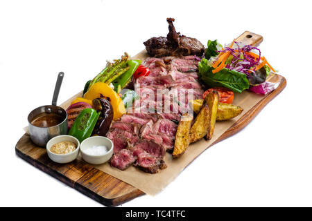 Nahaufnahme der geschnittenes T-Bone Steak Fiorentina tagliata di manzo mit gegrilltem Gemüse Bratkartoffeln frisch gemischter Salat barbecue Senf Meersalz Holz boa Stockfoto