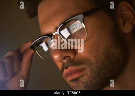 Jung und erfolgreich. Nahaufnahme von Stattlichen bärtiger Mann Anpassung Brillen und zur Seite schauen, während im Büro stehen. Erfolg Konzept. Männer Schönheit. Business Konzept Stockfoto