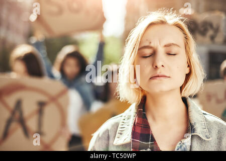 Vertrauen Frauen. Nahaufnahme Foto junge blonde Frau weint beim Stehen vor der Aktivistinnen auf der Straße während der Demonstration. Menschen demonstriert. Protest Konzept. Revolution Konzept Stockfoto