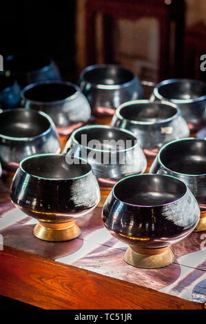 Sun Licht scheint durch die Fenster des Tempels auf Schalen aus Spenden von Gläubigen zu sammeln. Wat Phant Tao Tempel Chiang Mai. Thailand. Stockfoto