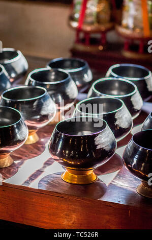 Sun Licht scheint durch die Fenster des Tempels auf Schalen aus Spenden von Gläubigen zu sammeln. Wat Phant Tao Tempel Chiang Mai. Thailand. Stockfoto