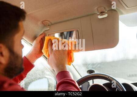 Foto von der Rückseite der Brunet mit orange rag Waschmaschine Spiegel der Auto Stockfoto