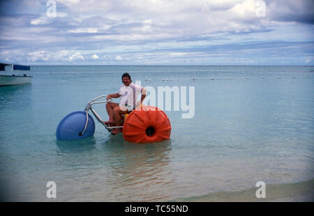 Der deutsche Sänger Klaus Baumgart posiert mit einem Dreirad vermutlich Tretboot am Strand auf den Bahamas, Ca. 1970er. Der deutsche Sänger Klaus Baumgart Posen mit einem Dreirad Tretboot am Strand wahrscheinlich auf die Bahamas, um 1970 n. Stockfoto